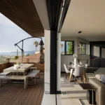 Modern home design showcasing a bump-out addition with seamless indoor-outdoor living, featuring a stylish dining area and ocean views.