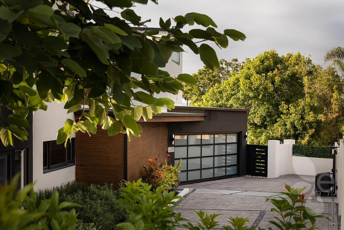 Driveway that leads up to close the garage door with landscaping on either side.