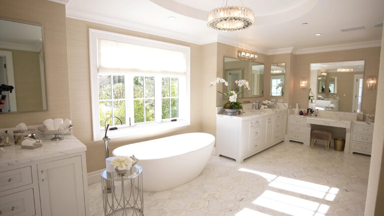 Luxurious bathroom with a freestanding tub, marble countertops, and elegant lighting fixtures. A spacious vanity and large mirrors enhance the design. For bathroom remodel tips, choose a contractor who matches your style and vision to create a functional, beautiful space.