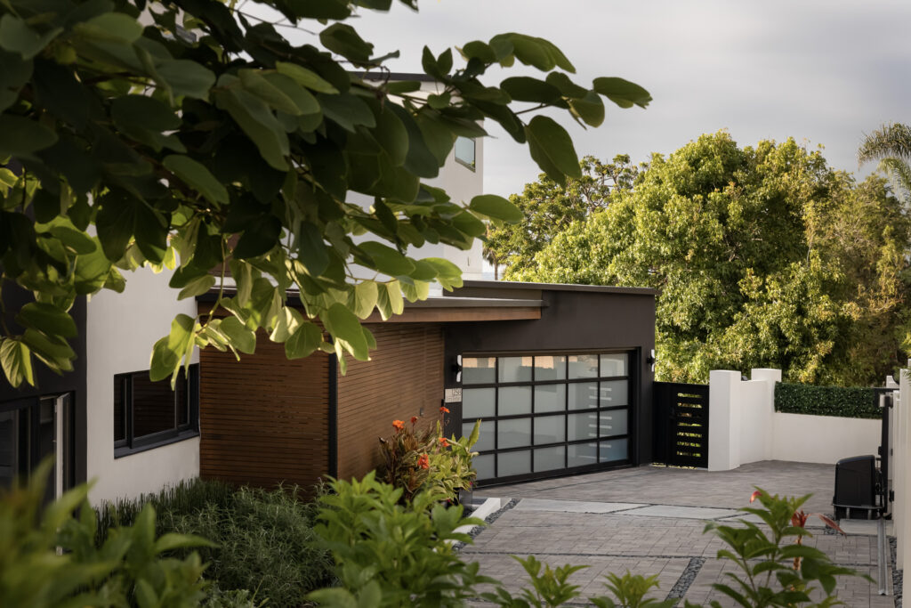 Luxury Home Remodeling & Landscaping with a modern garage, elegant wood accents, and vibrant greenery creating a stunning exterior design.